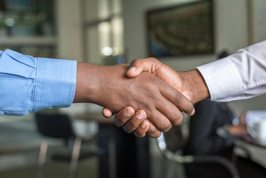 pexels photo 955395 955395 Close-up of two men's handshake symbolizing agreement in an office.